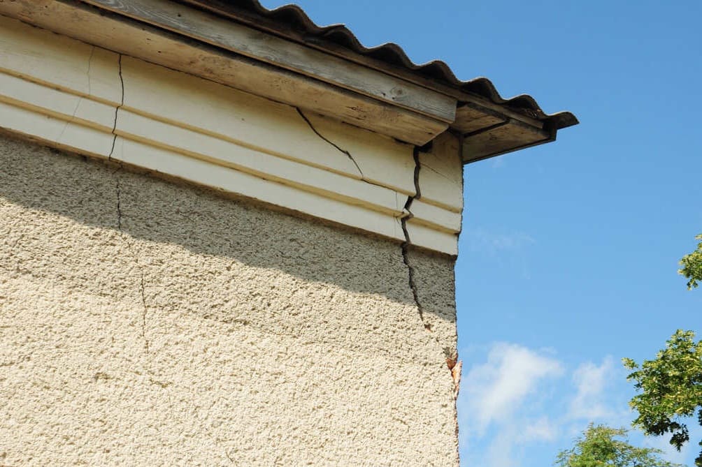 Rachaduras na parede perto do telhado de uma casa